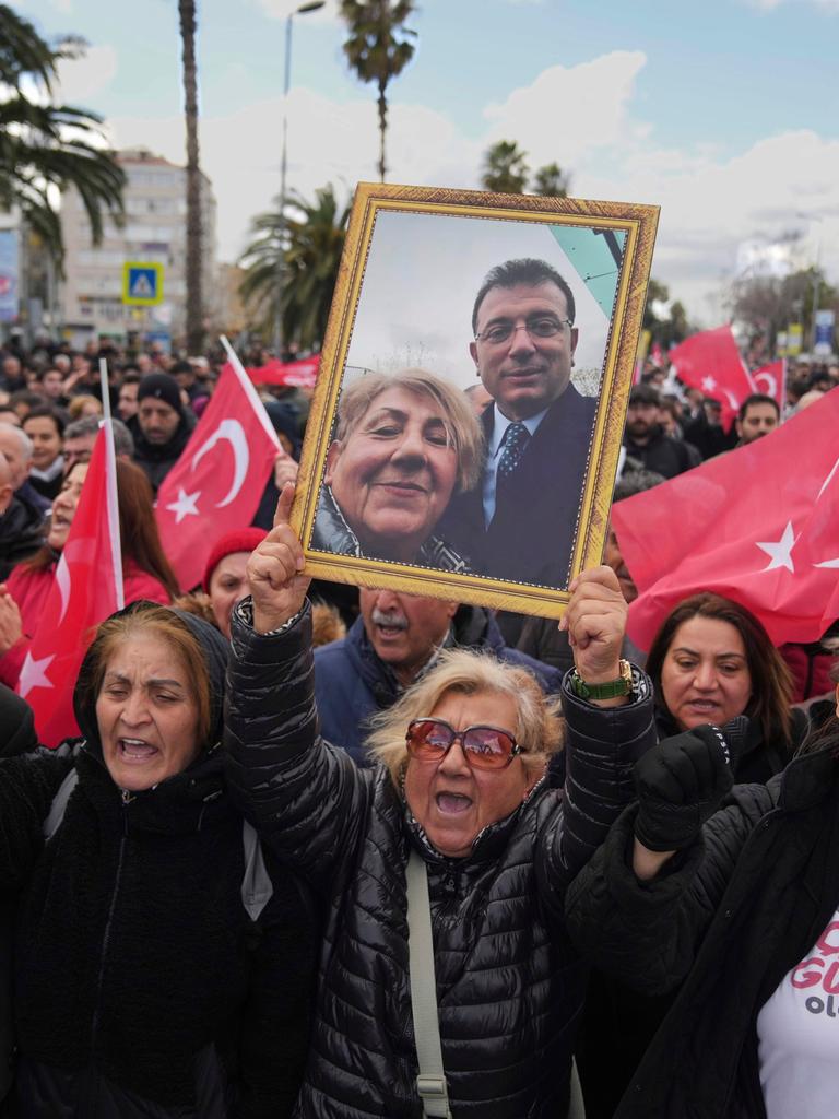 Ein Demonstrantin reckt ein gerahmtes Foto von ihr und Imamoglu in die Höhe. Um sie herum tausende weiterer Demonstranten u.a. mit türkischen Flaggen.