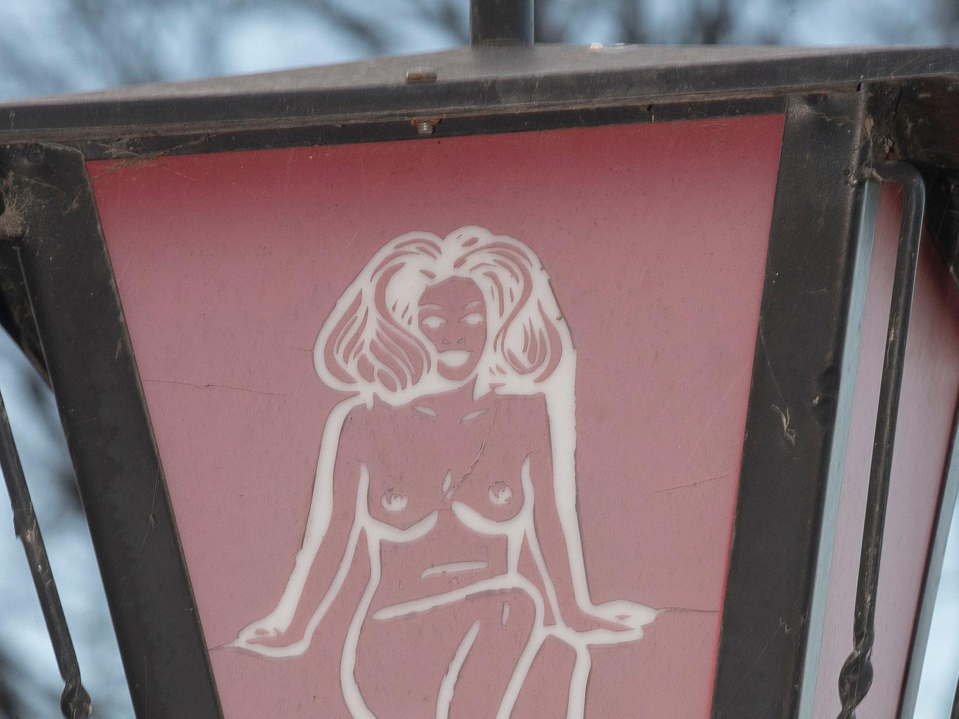 Eingang zum Bordell: Eine Straßenlaterne mit einer nackten Frau