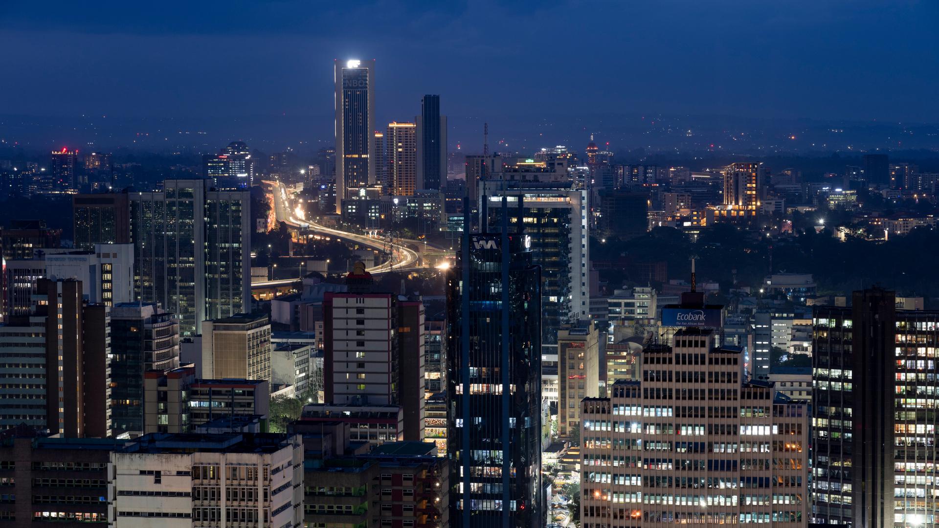 Die Innenstadt der kenianischen Hauptstadt Nairobi in nächtlichen Farben und mit Lichtern in den Gebäuden. Die Innenstadt der kenianischen Hauptstadt Nairobi in nächtlichen Farben und mit Lichtern in den Gebäuden.