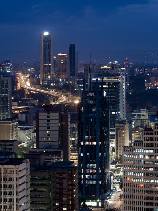 Die Innenstadt der kenianischen Hauptstadt Nairobi in nächtlichen Farben und mit Lichtern in den Gebäuden.