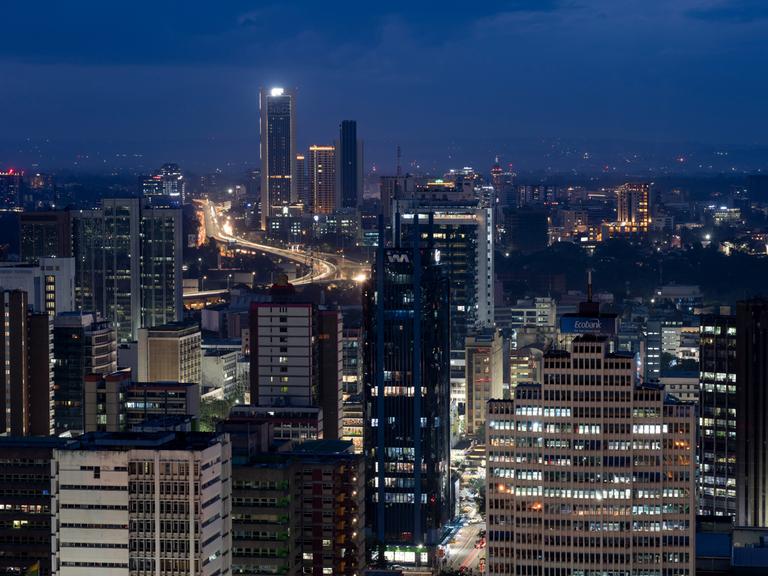 Die Innenstadt der kenianischen Hauptstadt Nairobi in nächtlichen Farben und mit Lichtern in den Gebäuden.