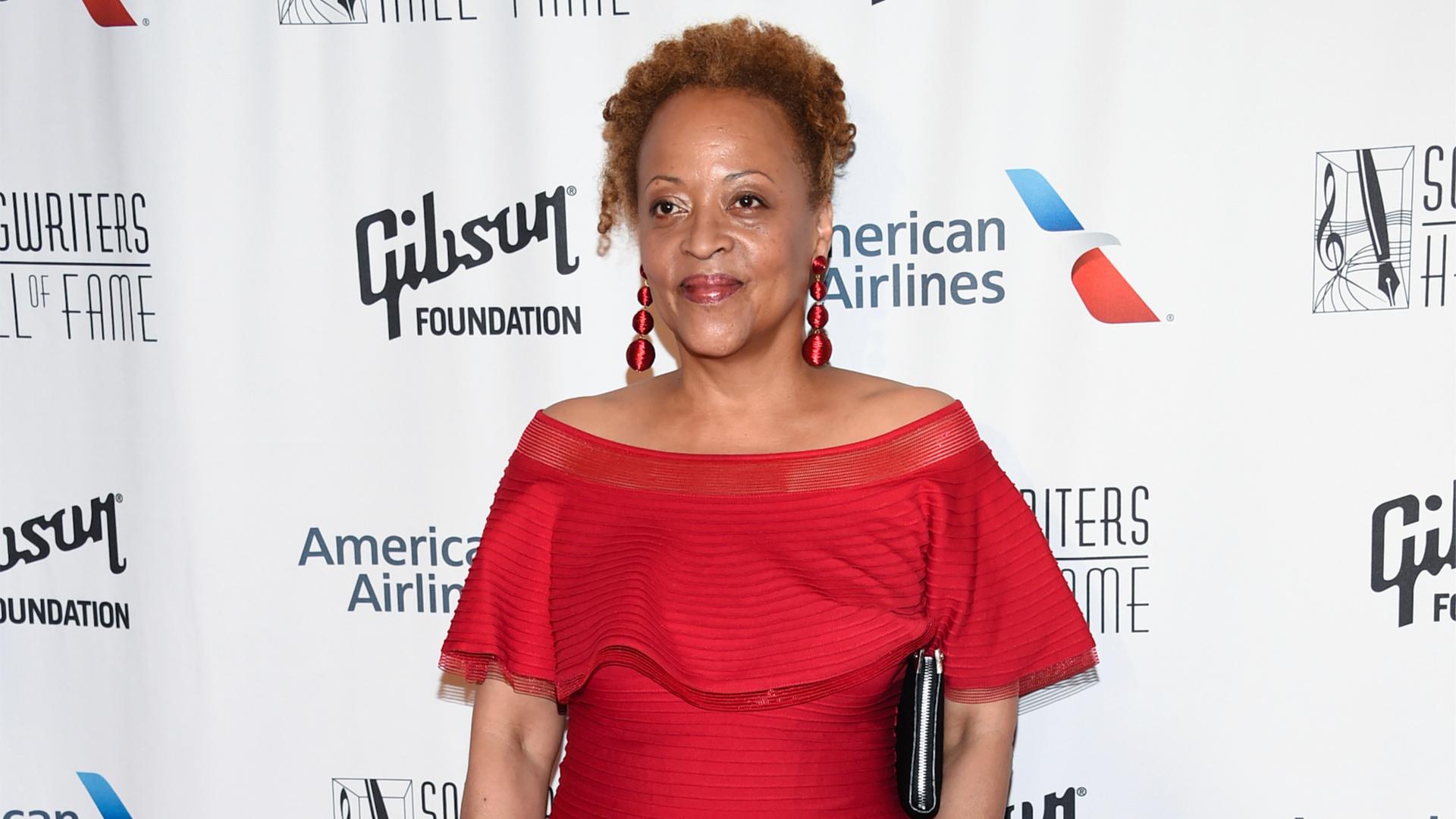 Cassandra Wilson steht in einem roten Kleid in der Hall of Fame vor einer Werbewand. Cassandra Wilson steht in einem roten Kleid in der Hall of Fame vor einer Werbewand.