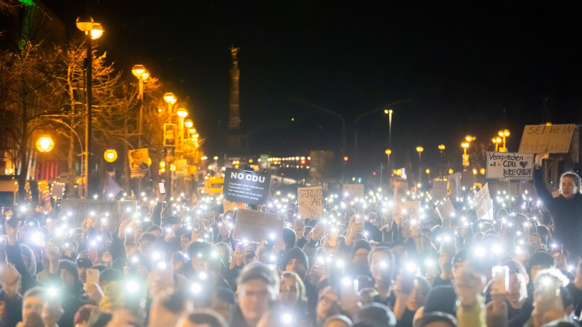 Teilnehmer einer Kundgebung gegen die Migrationspläne von Union und AfD halten vor der CDU-Bundesgeschäftsstelle (Konrad-Adenauer-Haus) ihr Handylampen in die Höhe. 