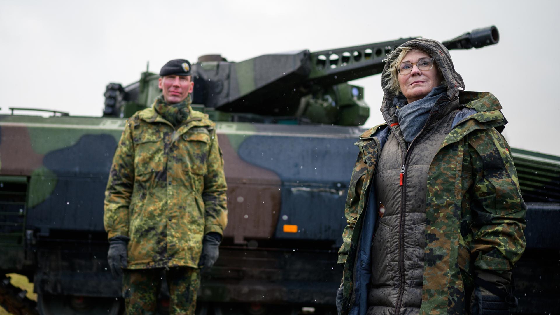Christine Lambrecht (r, SPD), Verteidigungsministerin, lässt sich bei ihrem Besuch der Panzerlehrbrigade 9 einen Schützenpanzer vom Typ Puma erklären.
