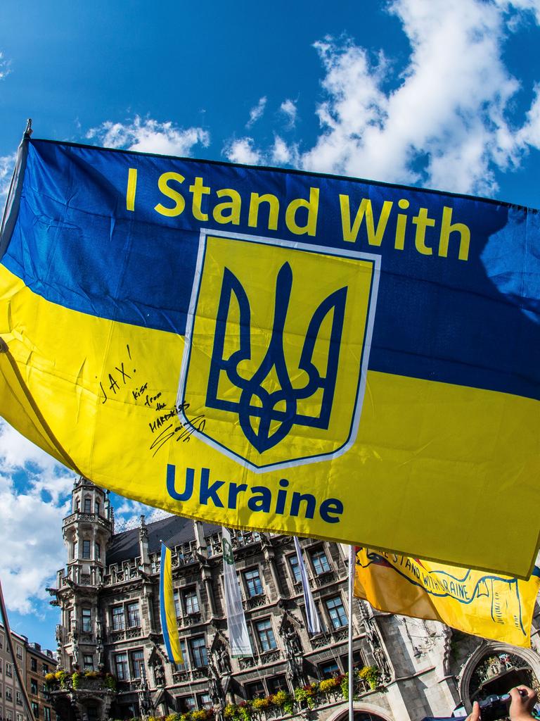 Bei einer Demonstration halten Protestierende ein Ukraine-Banner mit der Aufschrift "I stand with Ukraine" in die Höhe. 