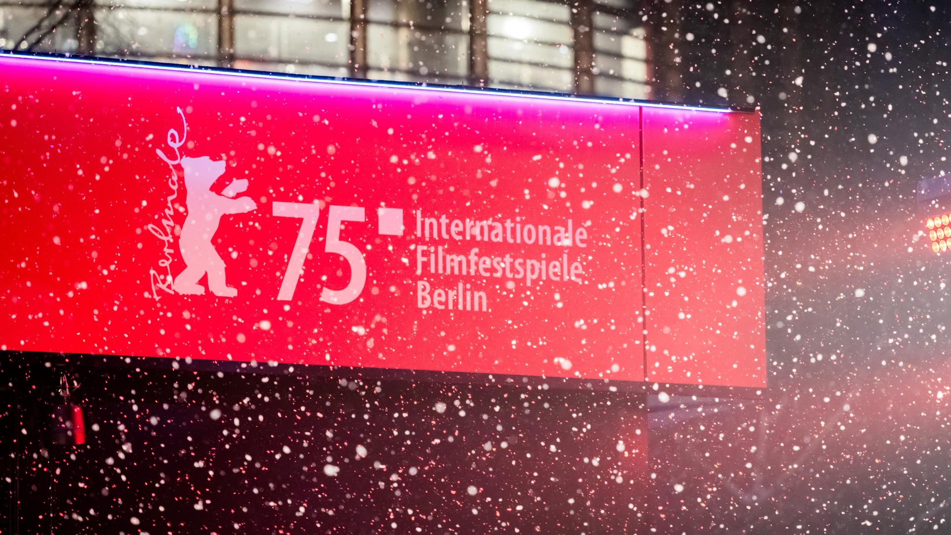 Schnee fällt vor dem Berlinale-Logo. 