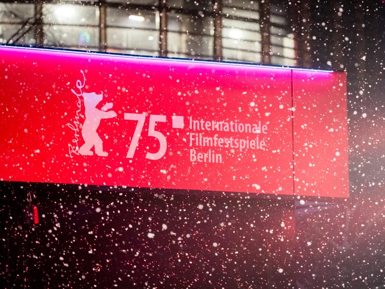 Schnee fällt vor dem Berlinale-Logo. 