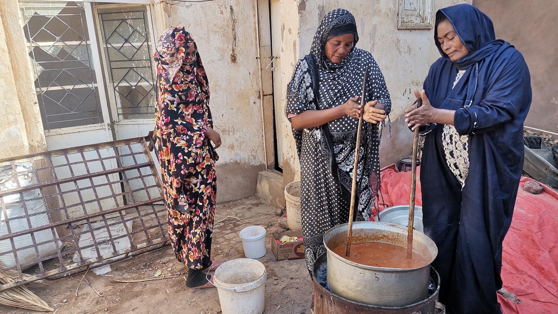 Folgen des Krieges: Menschen leiden Hunger. Hier kochen zwei Helferinnen in Omdurman Essen für Hilfebedürftige. 