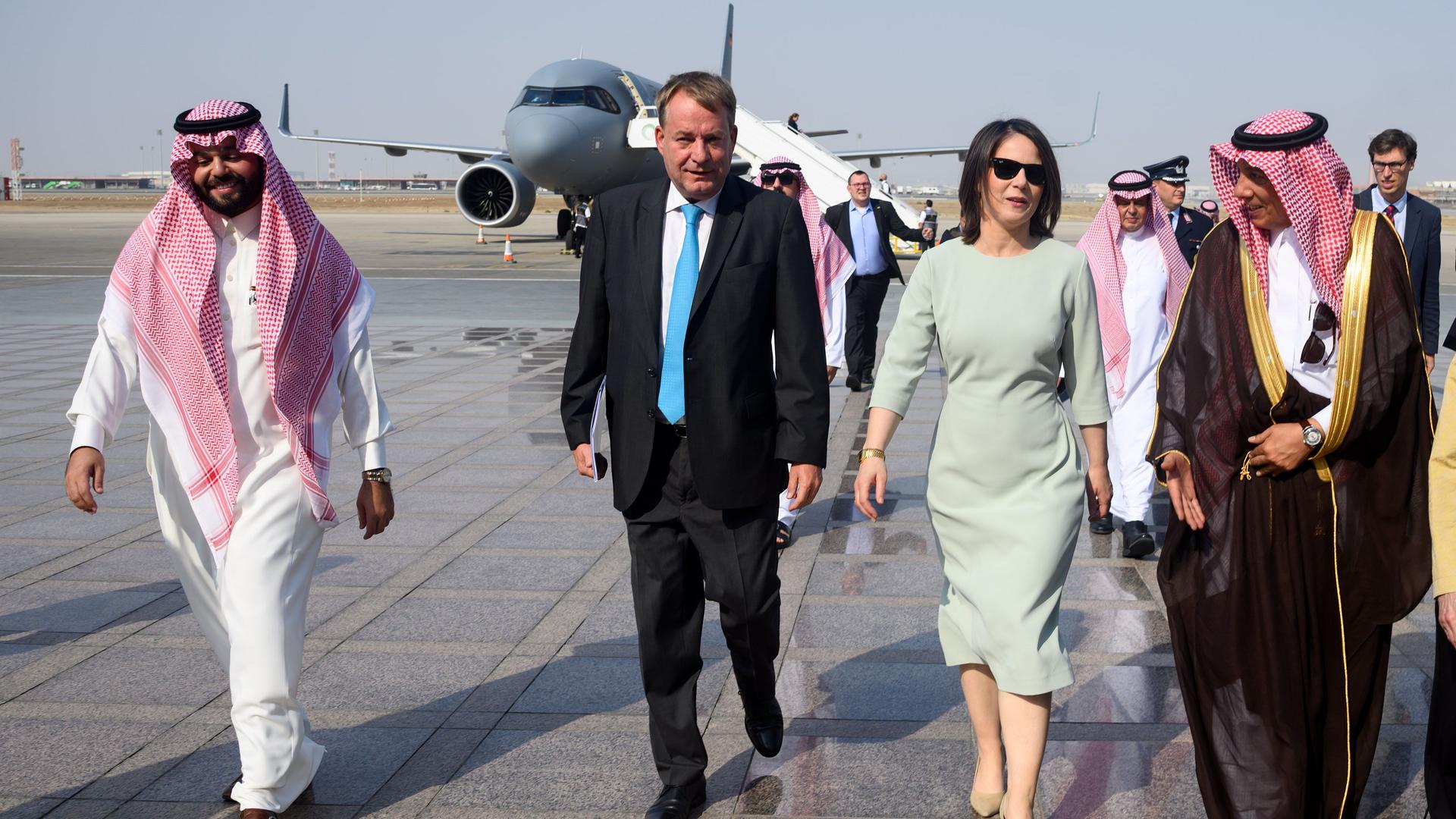 Saudi-Arabien, Dschidda: Annalena Baerbock (Bündnis 90/Die Grünen, Mitte r), Bundesaußenministerin, steigt auf dem King Abdulaziz International Airport aus einem Flugzeug der Flugbereitschaft der Bundeswehr und wird von Dieter Lamle (2.v.l), Botschafter Deutschlands in Saudi-Arabien, begrüßt.