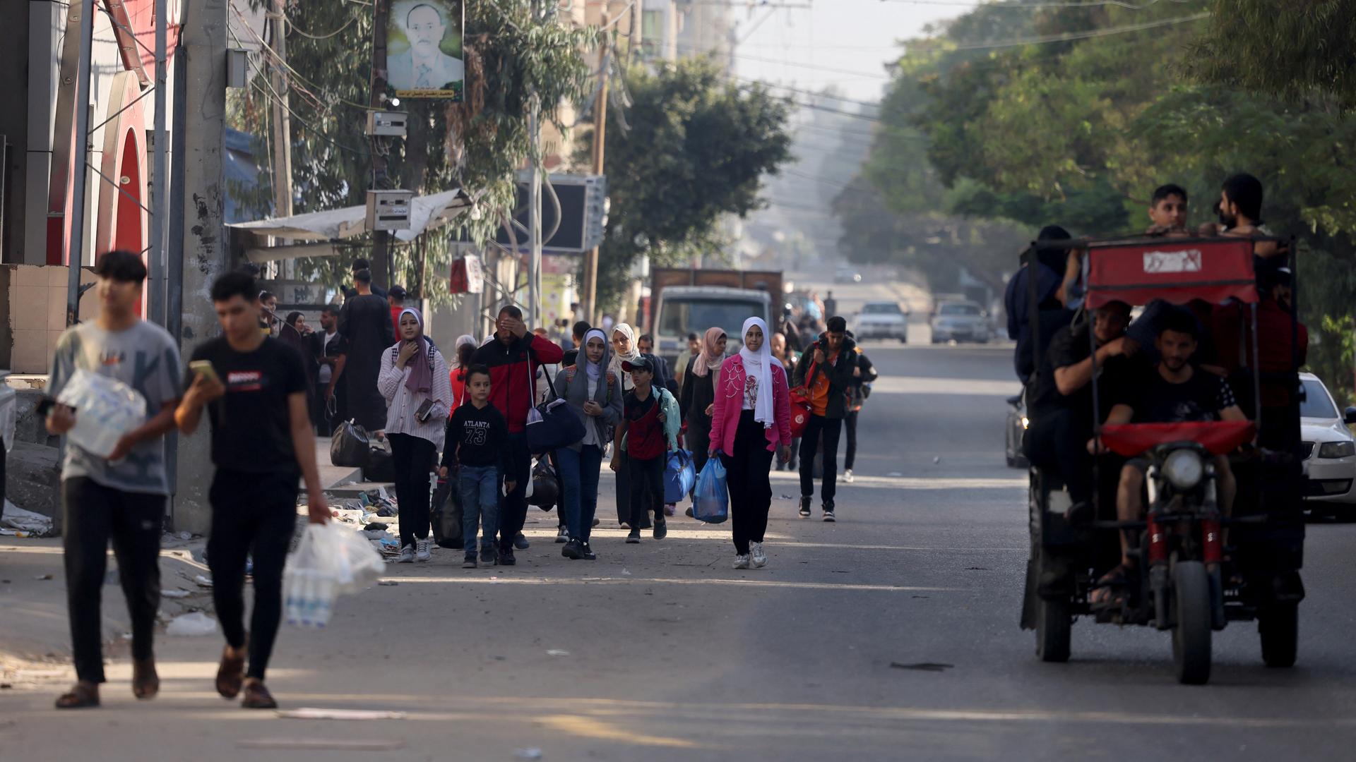 Palästinenser laufen mit Koppfern und Säcken bepackt aus Gaza-Stadt.