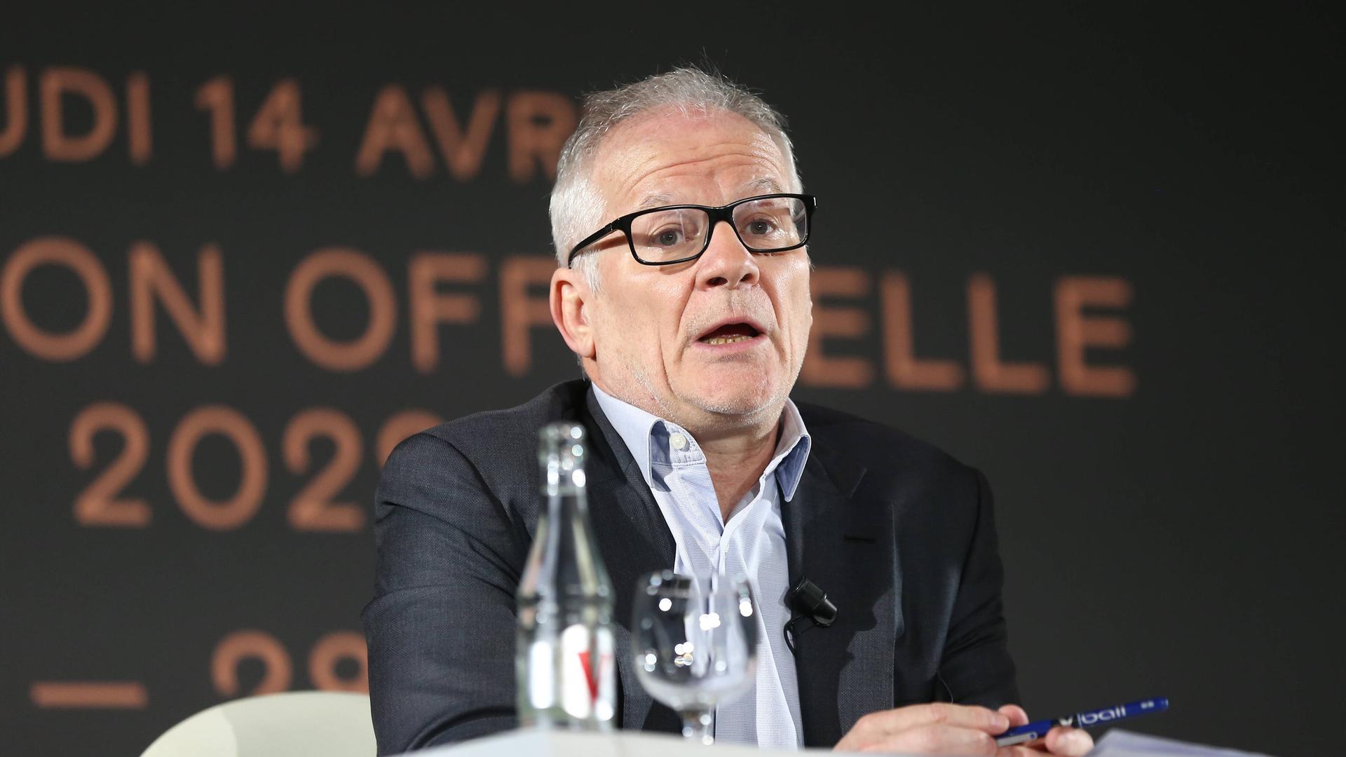 Thierry Frémaux sitzt an einem Tisch auf deiner Pressekonferenz des Filmfestivals in Cannes und spricht.