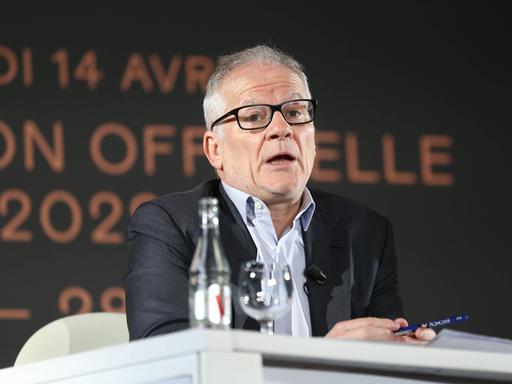 Thierry Frémaux sitzt an einem Tisch auf deiner Pressekonferenz des Filmfestivals in Cannes und spricht.