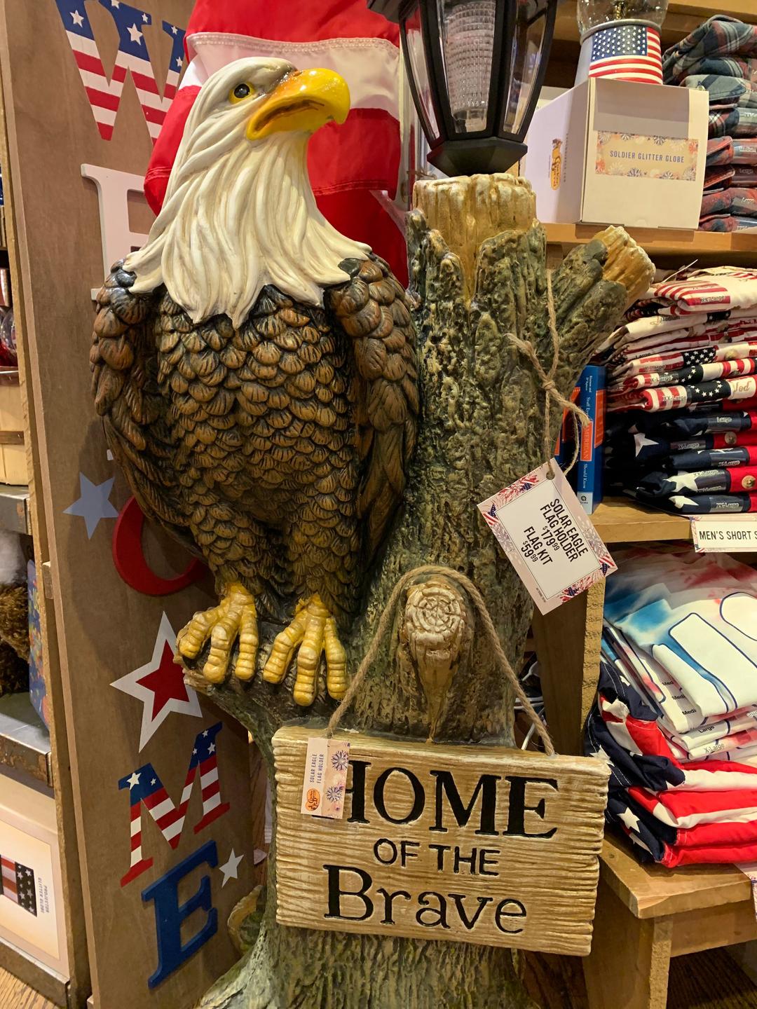 Ein Weißkopfseeadler aus Plastik sitzt auf einem Baumstamm in einem Souvenirshop.