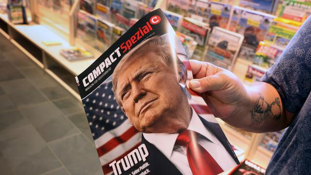 Eine Frau in einer Buch-Handlung hält eine Ausgabe von der Zeitschrift «Compact». Auf der Titel-Seite ist der frühere Präsident von den USA, Donald Trump.