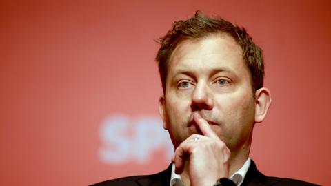 Man sieht Klingbeils Kopf. Er steht vor einer roten Wand mit weißem SPD-Schriftzug und hält nachdenklich einen Finger vor den Mund.