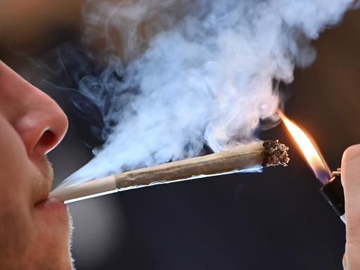 Ein junger Mann raucht einen Joint. 