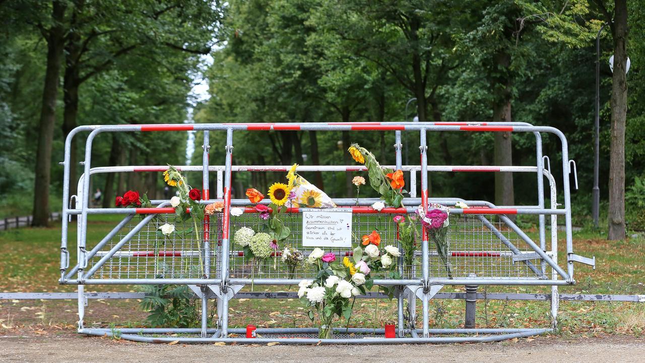 Am Tatort des CSD-Anschlags in Berlin haben Menschen an Absperrgittern Blumen niedergelegt, auf einem Schild steht "Wir müssen zusammenhalten. Gemeinsam sind wir stärker als der Hass und die Gewalt!"