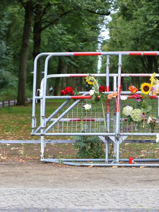 Am Tatort des CSD-Anschlags in Berlin haben Menschen an Absperrgittern Blumen niedergelegt, auf einem Schild steht "Wir müssen zusammenhalten. Gemeinsam sind wir stärker als der Hass und die Gewalt!"