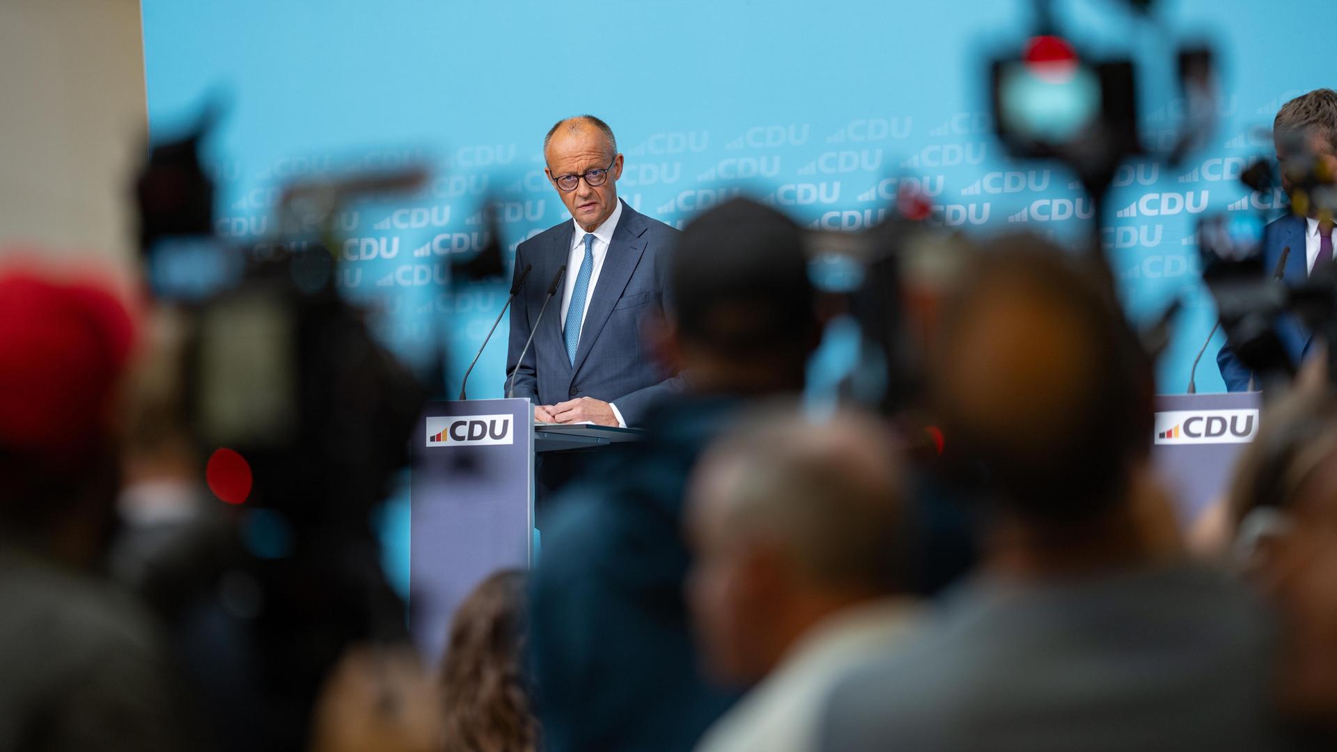 Bundeskanzler Friedrich Merz an einem Rednerpult, umringt von Kameras