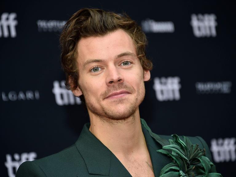 Harry Styles steht vor einer schwarzen Wand mit der Aufschrift "tiff" beim Toronto International Film Festival