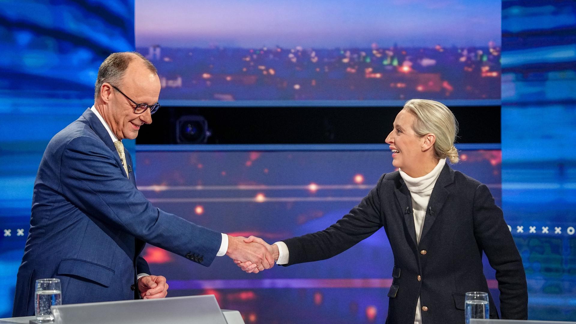 Unions-Kanzlerkandidat Friedrich Merz und Alice Weidel, Kanzlerkandidatin der AfD, geben sich die Hand bei einer TV-Debatte am 16.2.2025.