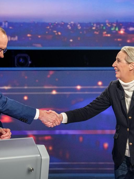 Unions-Kanzlerkandidat Friedrich Merz und Alice Weidel, Kanzlerkandidatin der AfD, geben sich die Hand bei einer TV-Debatte am 16.2.2025.