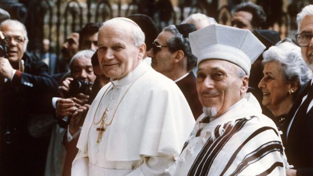 Als erster Papst in der fast 2000jährigen Geschichte des Christentums besucht Papst Johannes Paul II. (l) am 13.4.1986 ein jüdisches Gotteshaus, die Große Synagoge in Rom. Rechts der Rabbiner Elio Toaff.