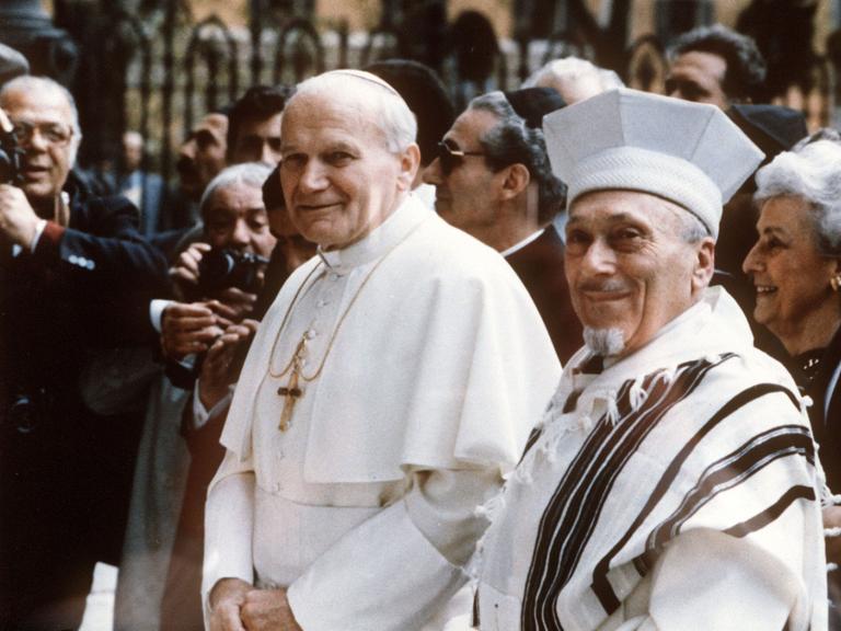 Als erster Papst in der fast 2000jährigen Geschichte des Christentums besucht Papst Johannes Paul II. (l) am 13.4.1986 ein jüdisches Gotteshaus, die Große Synagoge in Rom. Rechts der Rabbiner Elio Toaff.