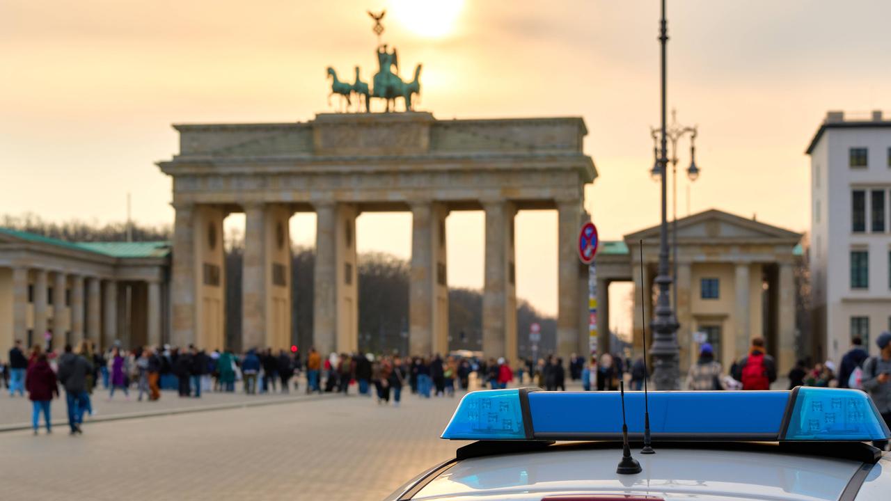 Ein Streifenwagen der Berliner Polizei steht vor dem Brandenburger Tor.