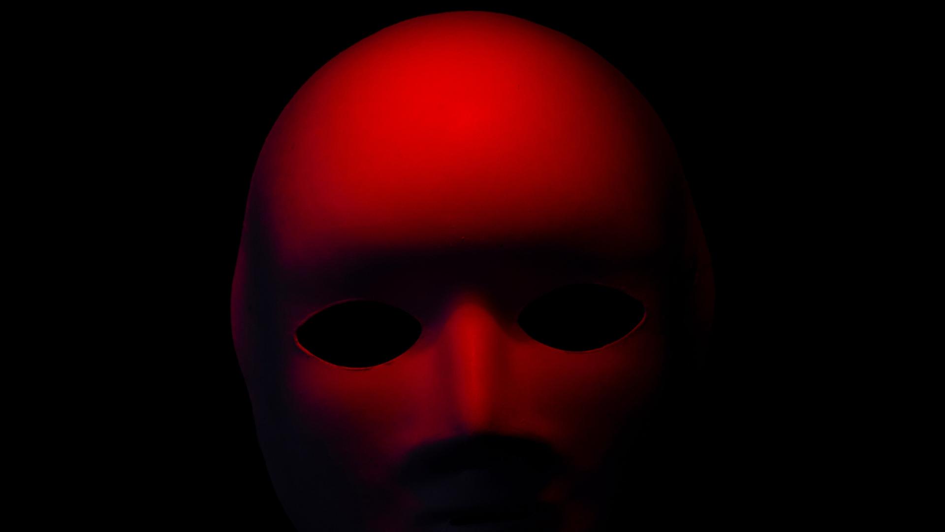 Eine rote Maske auf schwarzem Hintergrund.