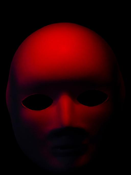 Eine rote Maske auf schwarzem Hintergrund.