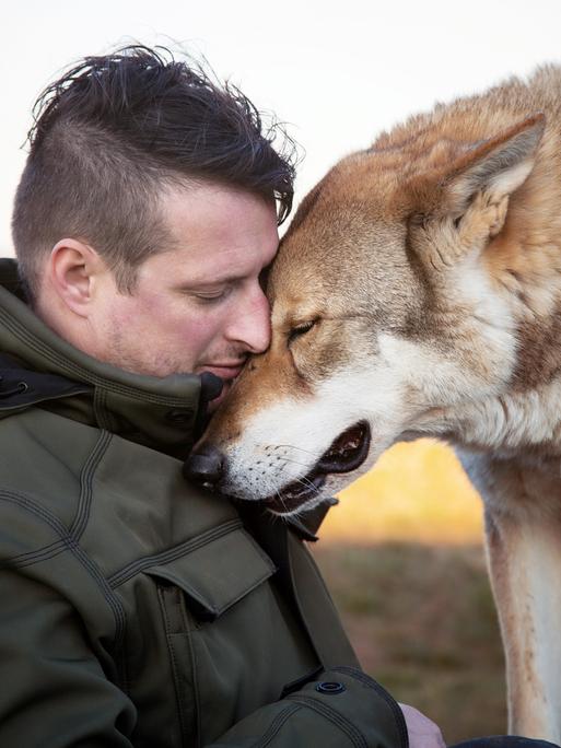 Profilbild von Gerd Schuster und einem großen Hund, die ihre Köpfe aneinanderschmiegen.