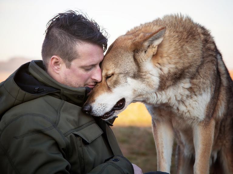 Profilbild von Gerd Schuster und einem großen Hund, die ihre Köpfe aneinanderschmiegen.