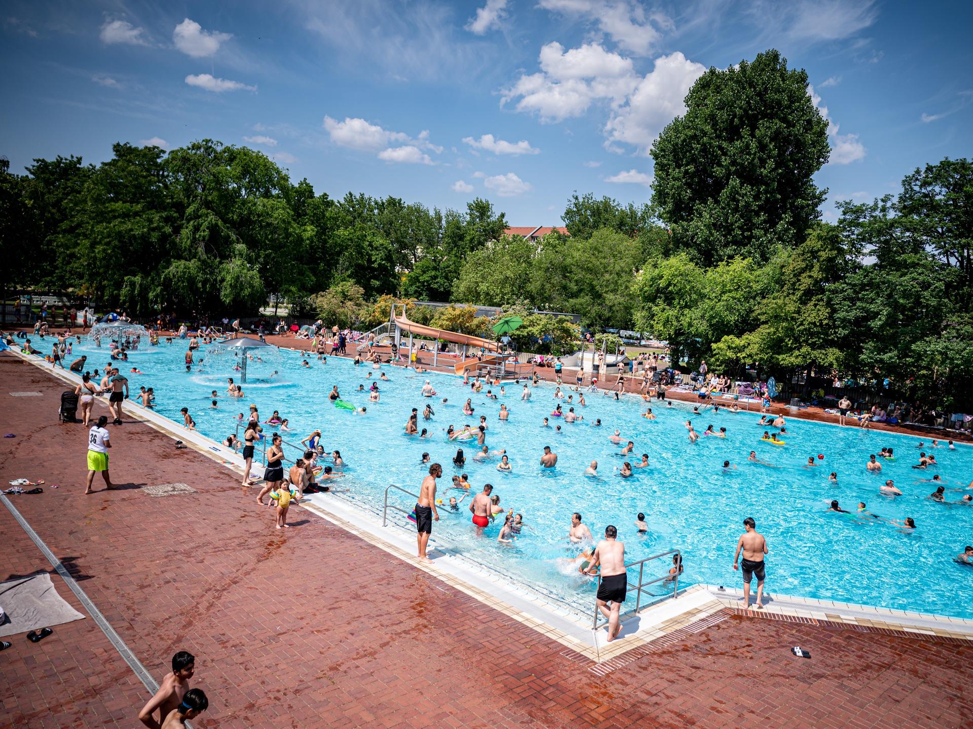 Viele Menschen verbringen einen sommerlich warmen Tag im Berliner Prinzenbad.