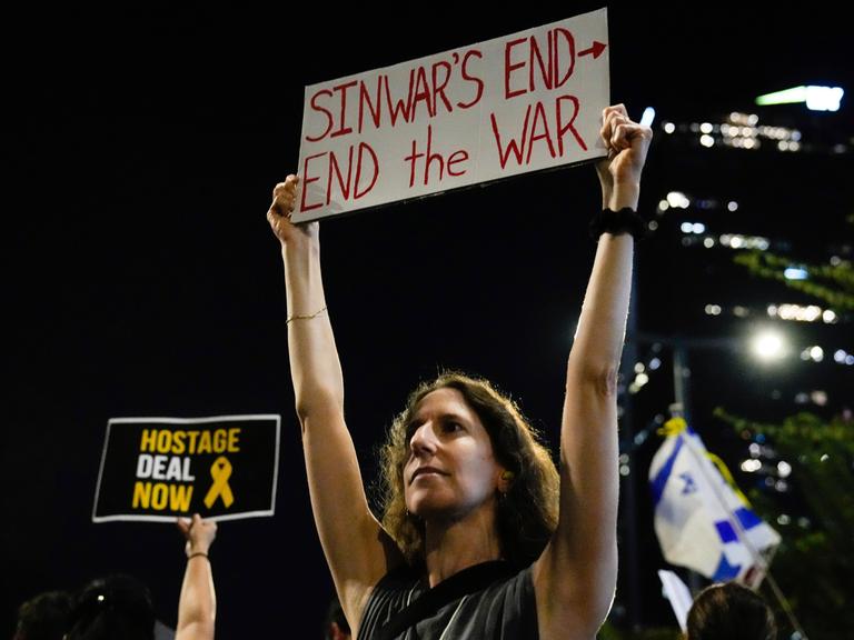 Eine Demonstrantin hält ein Schild über die Ermordung des Hamas-Führers Yahya Sinwar während einer Demonstration, bei der ein Waffenstillstandsabkommen und die sofortige Freilassung der von der Hamas festgehaltenen Geiseln gefordert wird.