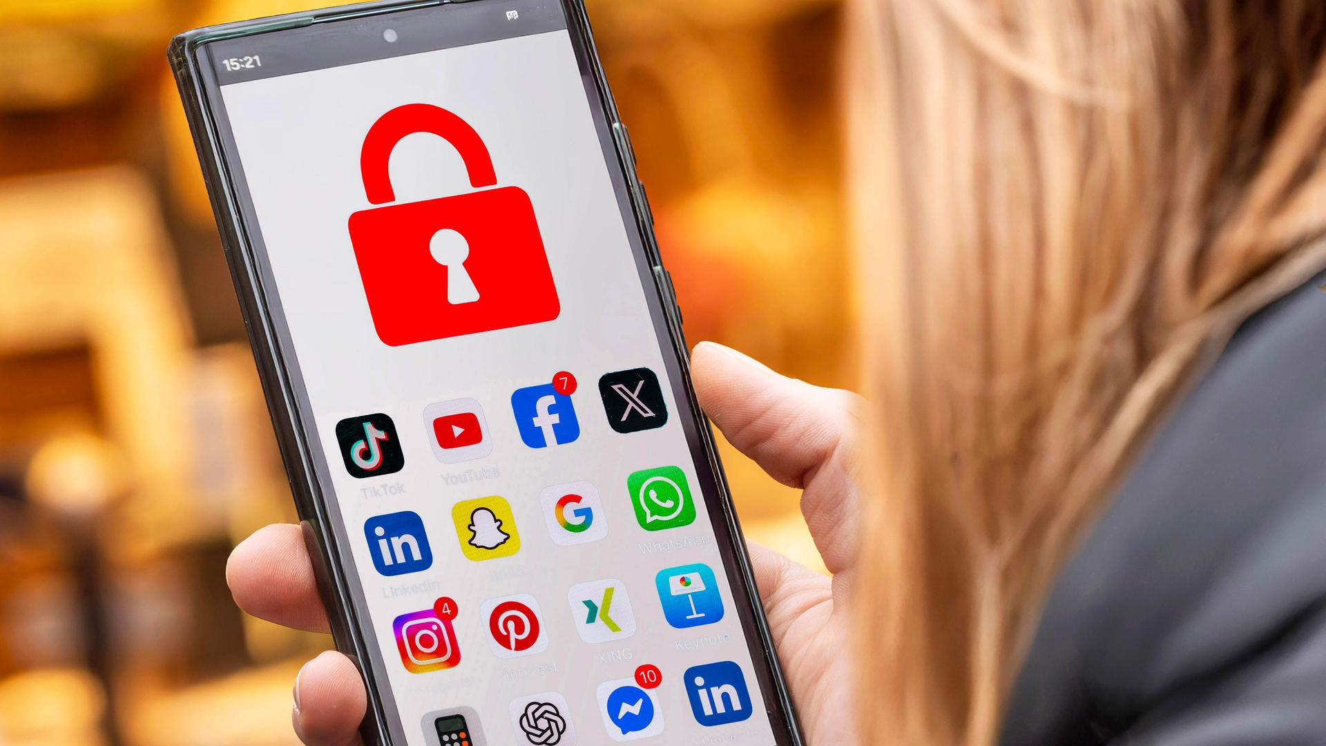 Symbolfoto: Schülerin mit Handy und Social Media Apps, die gesperrt sind Symbolfoto: Schülerin mit Handy und Social Media Apps, die gesperrt sind