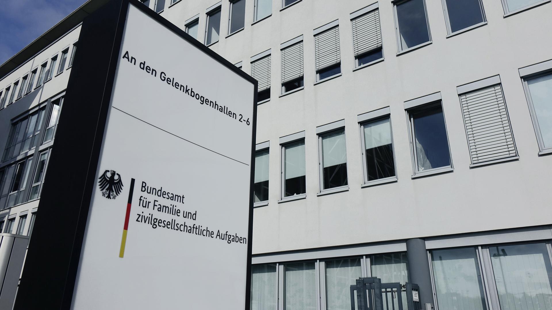 Ein Schild mit der Aufschrift "Bundesamt für Familie und zivilgesellschaftliche Aufgaben" steht vor einem Bürogebäude.
