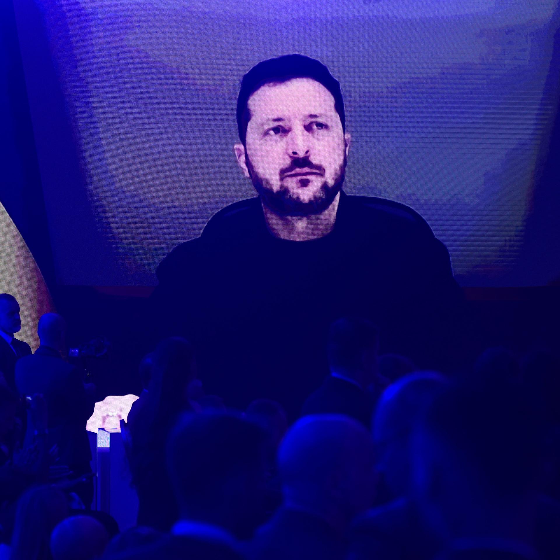 Teilnehmer verfolgen auf einer Großbildleinwand die Rede des ukrainischen Präsidenten Wolodymyr Selenskyj auf dem Warschauer Sicherheitsforum in Warschau.