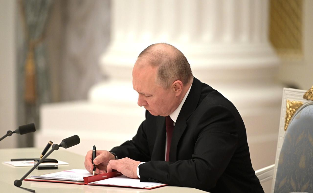 Der russische Präsident Wladimir Putin unterzeichnet am 21. Februar 2022 ein Dokument