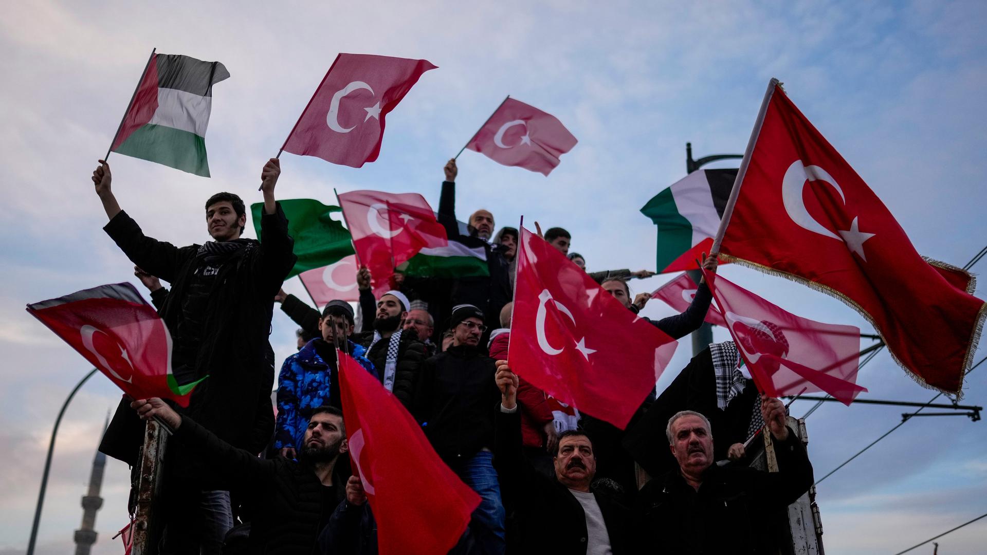 Das Foto zeigt Demonstranten in Istanbul, die palästinensische sowie türkische Fahnen schwenken, Das Foto zeigt Demonstranten in Istanbul, die palästinensische sowie türkische Fahnen schwenken,