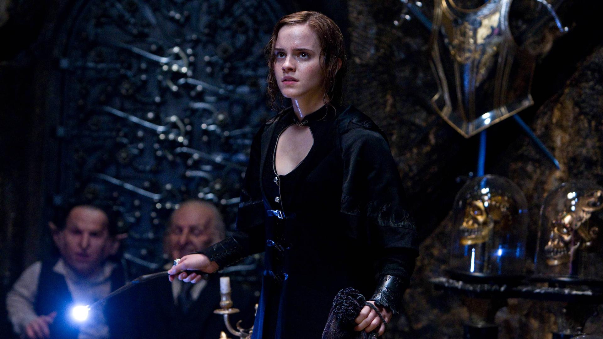 Die Schauspielerin Emma Watson als Hermine Granger hält einen Zauberstab in der Hand.   