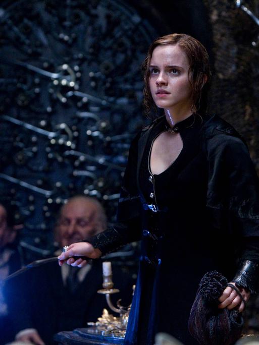 Die Schauspielerin Emma Watson als Hermine Granger hält einen Zauberstab in der Hand.   
