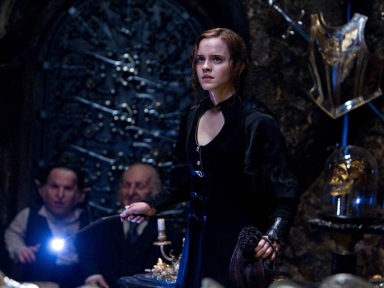 Die Schauspielerin Emma Watson als Hermine Granger hält einen Zauberstab in der Hand.   