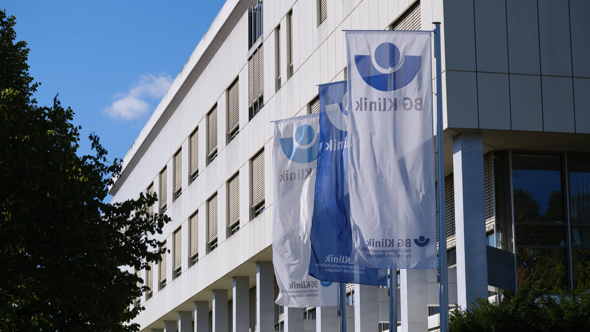 Außenaufnahme der BG Klinik in Tübingen. Davor stehen Fahnen mit dem Logo der Klinik.