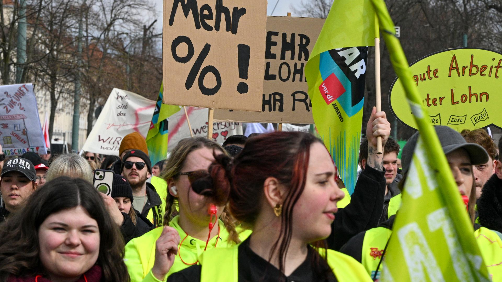 Demonstranten laufen mit Pappschildern und Wanrwesten bei der Fortsetzung der Tarifverhandlungen für den öffentlichen Dienst in einem Zug durch Potsdam.