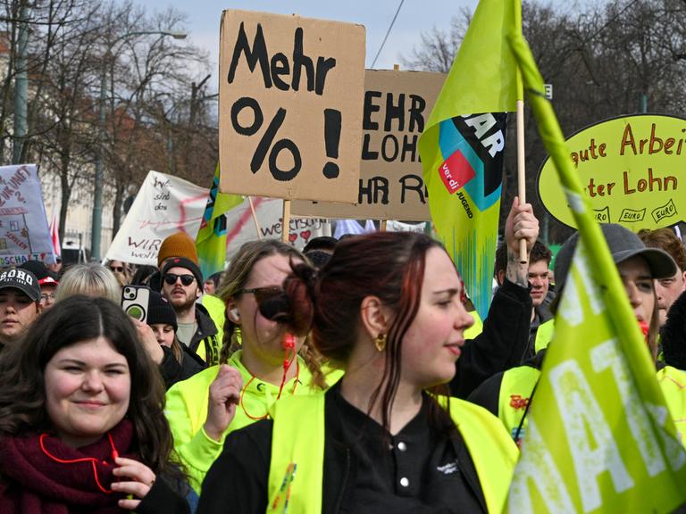 Demonstranten laufen mit Pappschildern und Wanrwesten bei der Fortsetzung der Tarifverhandlungen für den öffentlichen Dienst in einem Zug durch Potsdam.