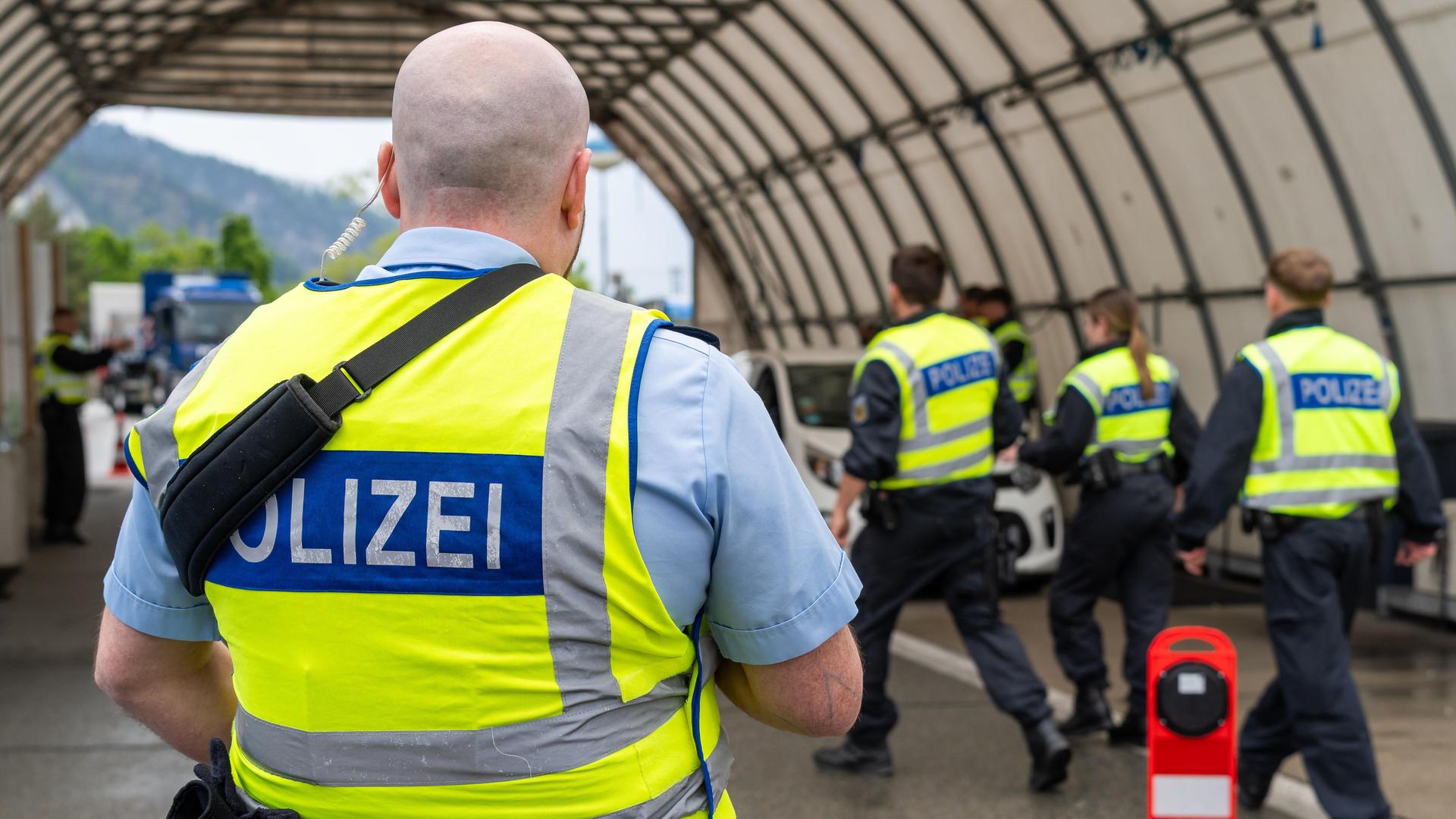 Mehrere Polizisten stehen bei einer Grenzkontrolle der Bundespolizei an der Kontrollstelle Kiefersfelden, Inntal Ost, an der Autobahn A93 zwischen Deutschland und Österreich. Mehrere Polizisten stehen bei einer Grenzkontrolle der Bundespolizei an der Kontrollstelle Kiefersfelden, Inntal Ost, an der Autobahn A93 zwischen Deutschland und Österreich.