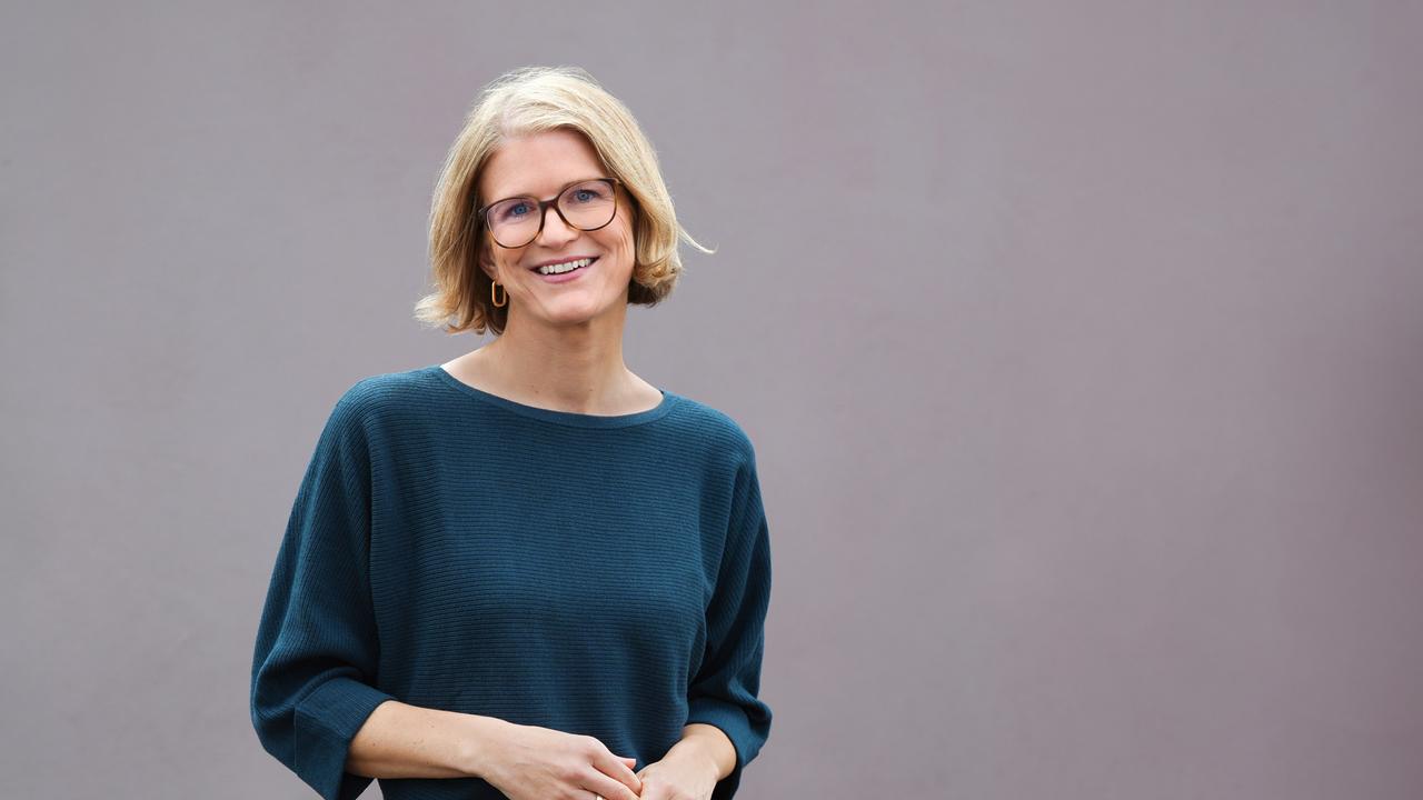 Portrait von Susanne Schwarzbach, die lächelnd mit geneigtem Kopf in die Kamera blickt.