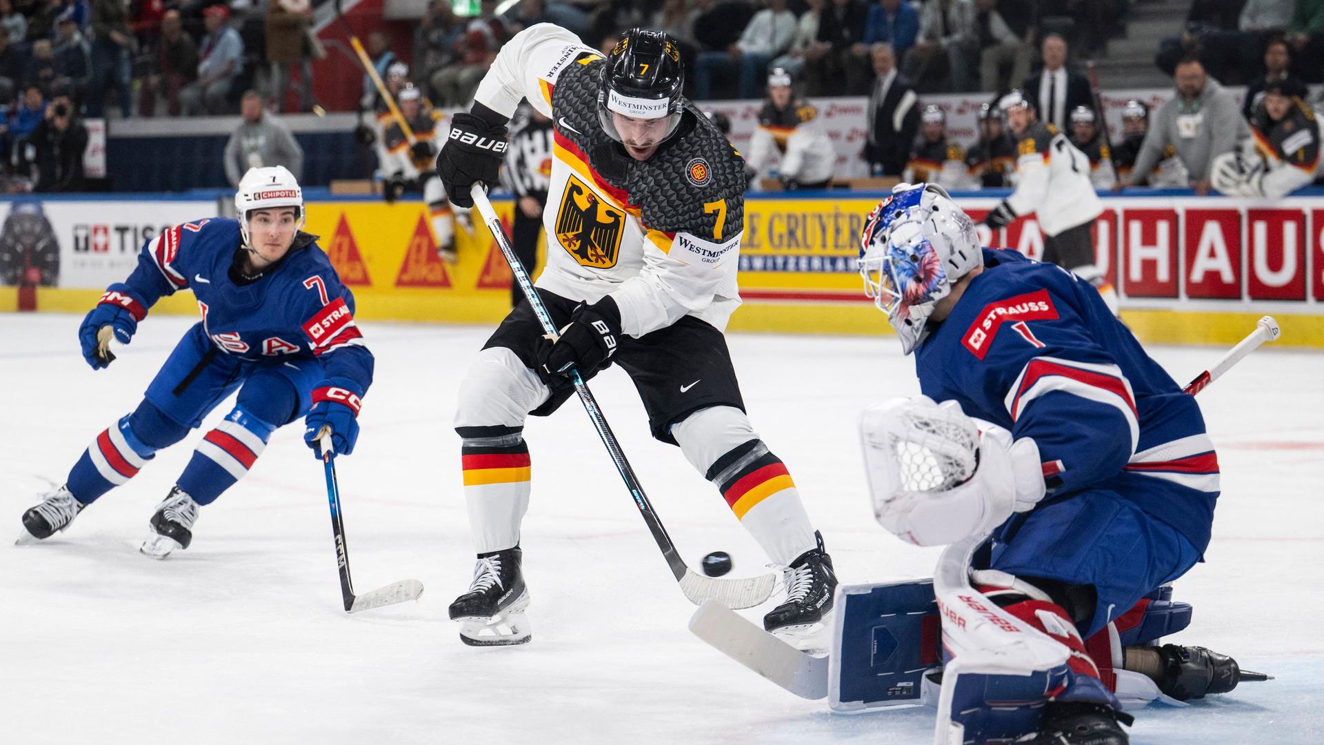 Der deutsche Maximilian Kastner kämpft mit dem US-amerikanischen Torwart Cooley um den Puck. Der deutsche Maximilian Kastner kämpft mit dem US-amerikanischen Torwart Cooley um den Puck.