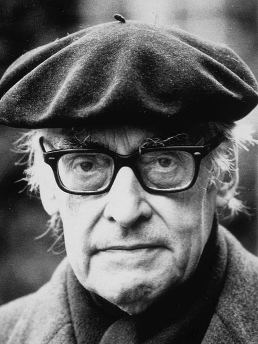 Historische undatiertes schwarz-weiß Porträt zeigt Raymond Queneau. Ein älterer Mann mit Baskenmütze und Hornbrille 